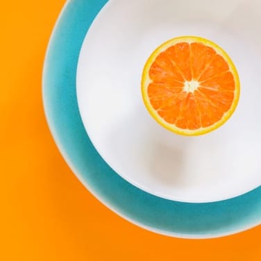 An orange half on a plate with blue edge 